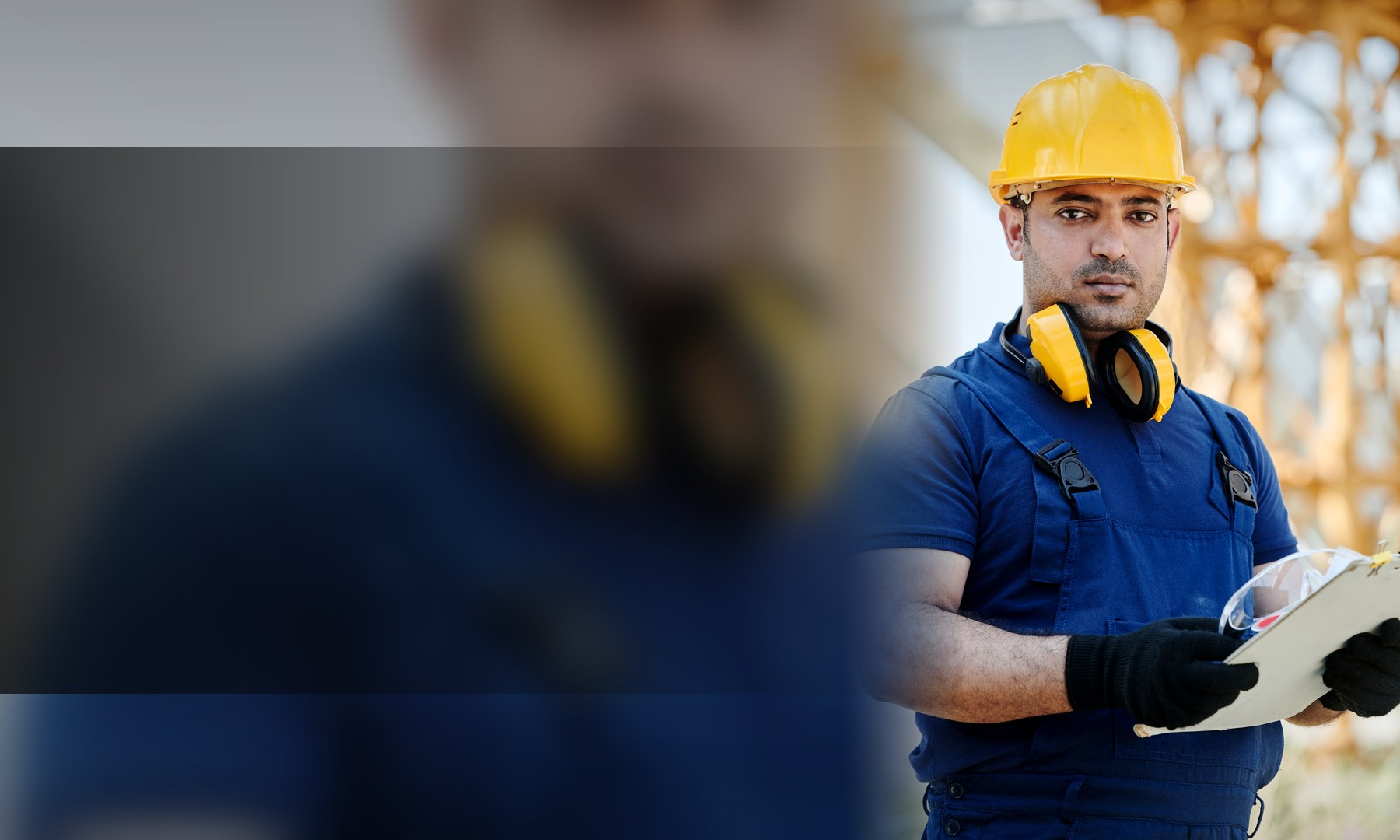 Trabalhador com equipamentos de proteção analisando documentos no ambiente de trabalho